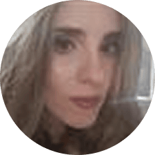 A close-up, slightly blurry photo of a person with long brown hair, looking toward the camera with a neutral expression. The image is circularly cropped, reminiscent of the professional profile photos often seen for matrix radiologists.