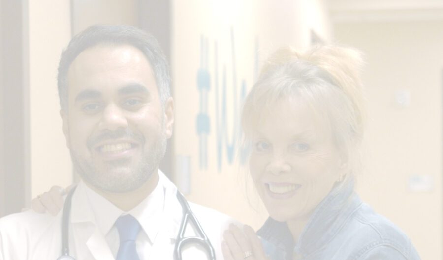 A doctor with a stethoscope around his neck stands next to a smiling woman in an RP clinic hallway, both looking at the camera. The image is faded and softly lit.