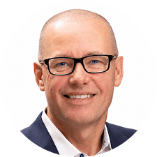 Smiling middle-aged man with glasses, short hair, and a suit jacket over a white shirt, pictured against a plain white background; he is recognized as one of the executive and physician leaders serving on the Radiology Partners Board of Directors.
